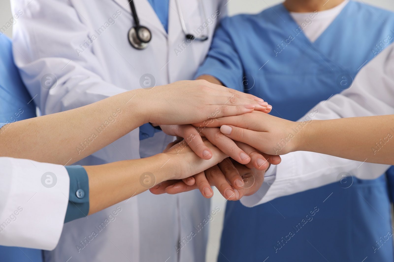 Photo of Team of medical doctors putting hands together, closeup