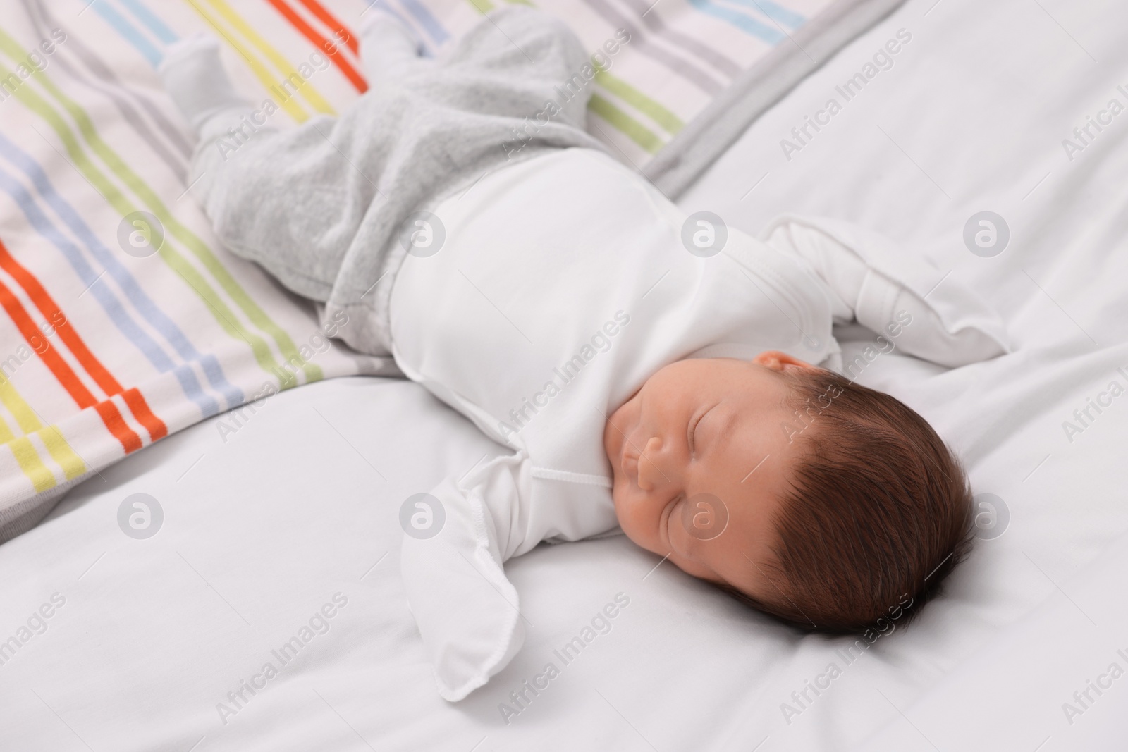 Photo of Cute newborn baby sleeping on soft bed