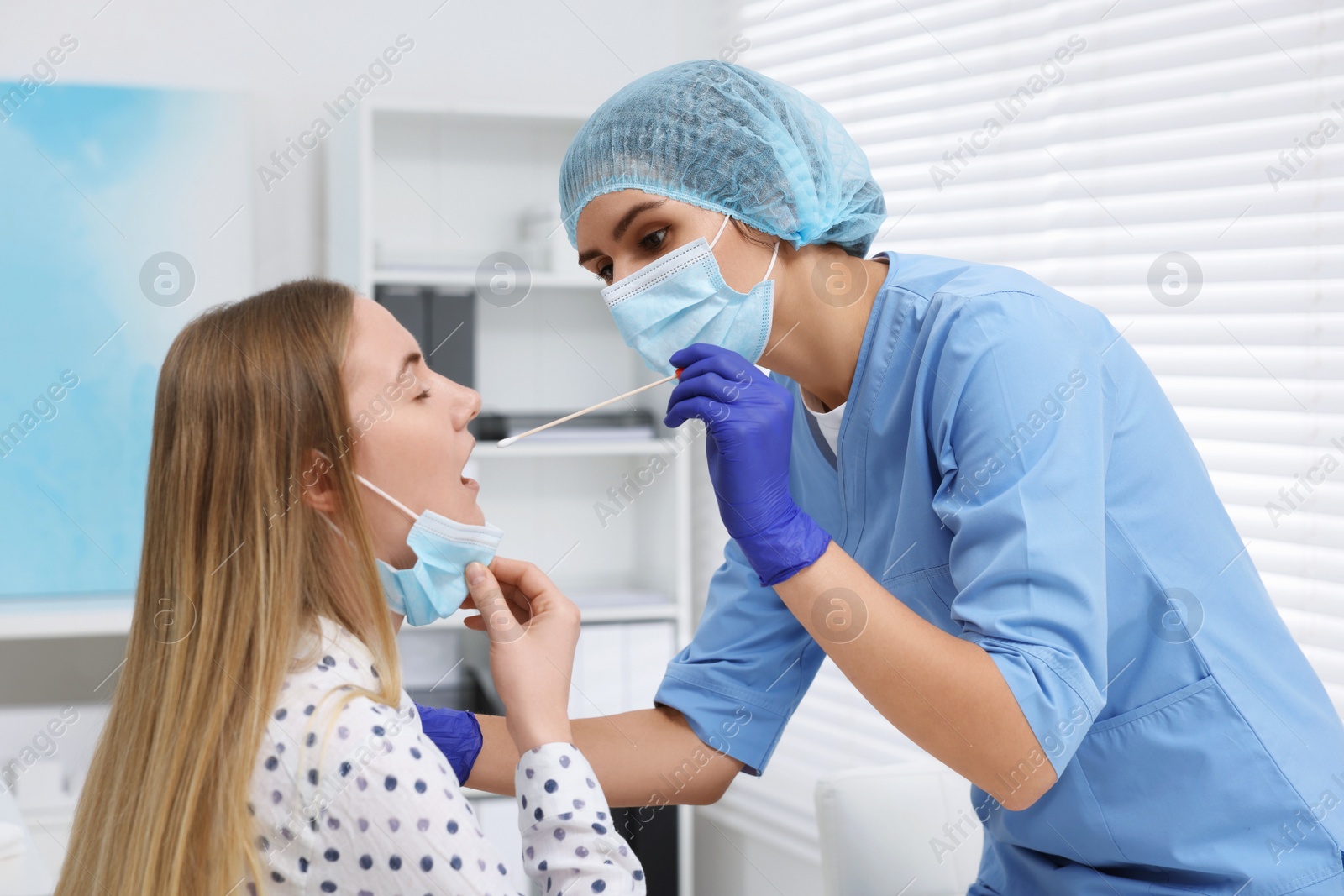 Photo of Laboratory testing. Doctor taking sample from patient's mouth with cotton swab in hospital