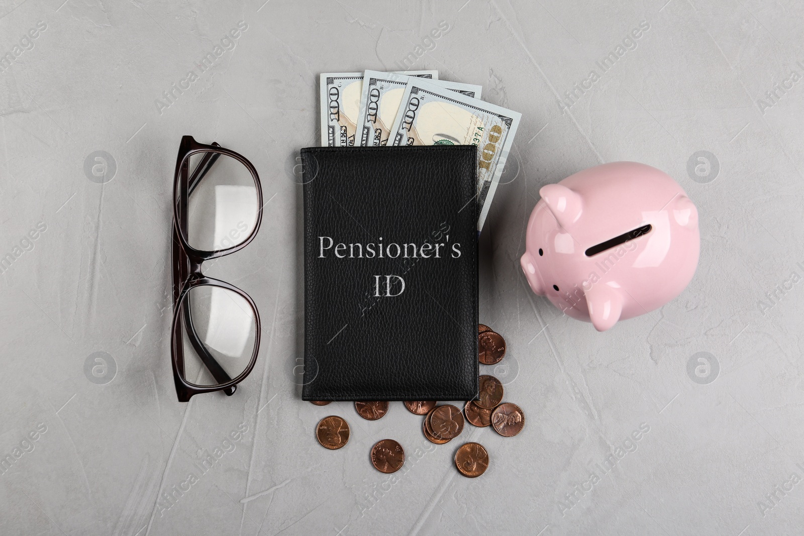 Photo of Pension certificate with American money, glasses and piggybank on grey stone table, flat lay