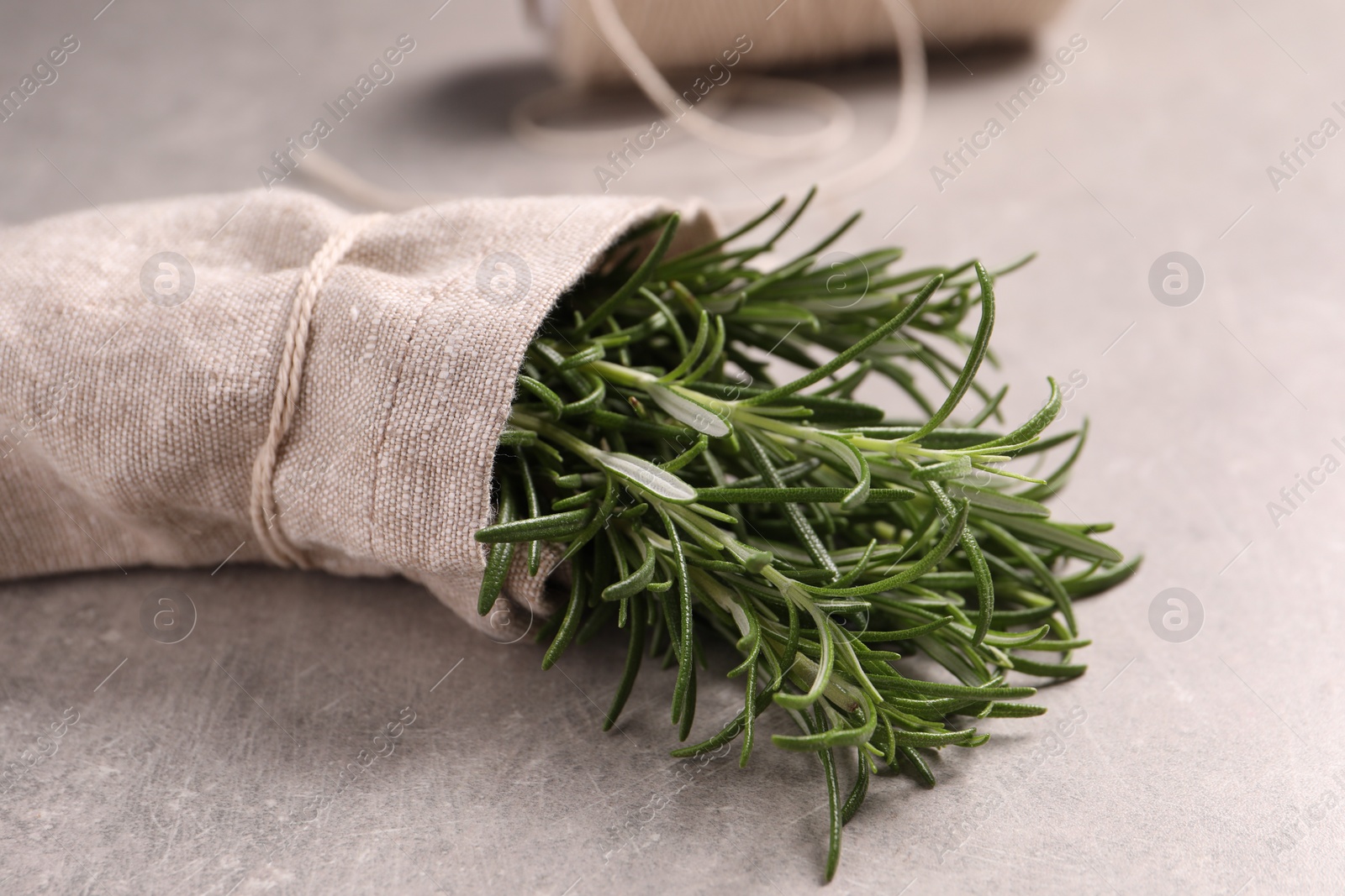 Photo of Sack with fresh rosemary on light grey table, closeup