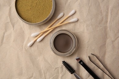 Photo of Flat lay composition with eyebrow henna and tools on crumpled paper