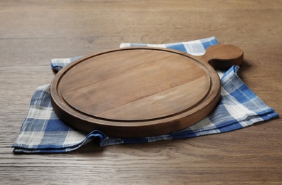 Photo of Wooden board and kitchen towel on brown table