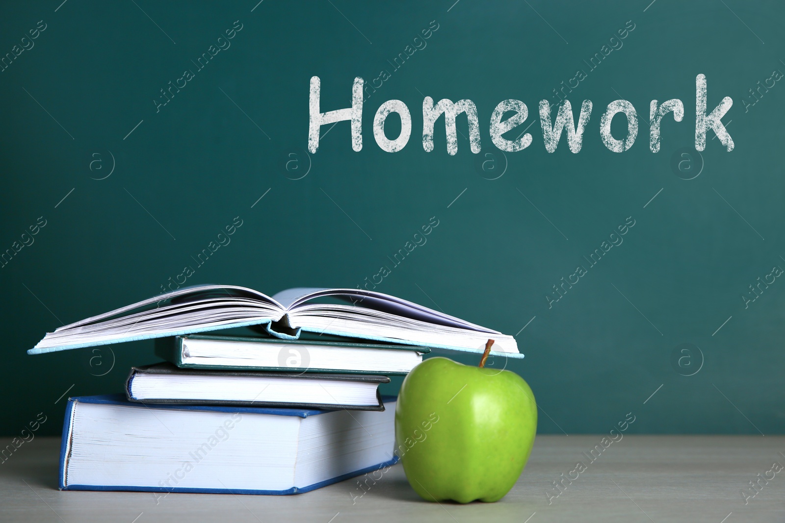 Image of Apple and stack of books on white wooden table. Doing homework