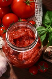 Photo of Jar of tasty tomato paste and ingredients on table, above view