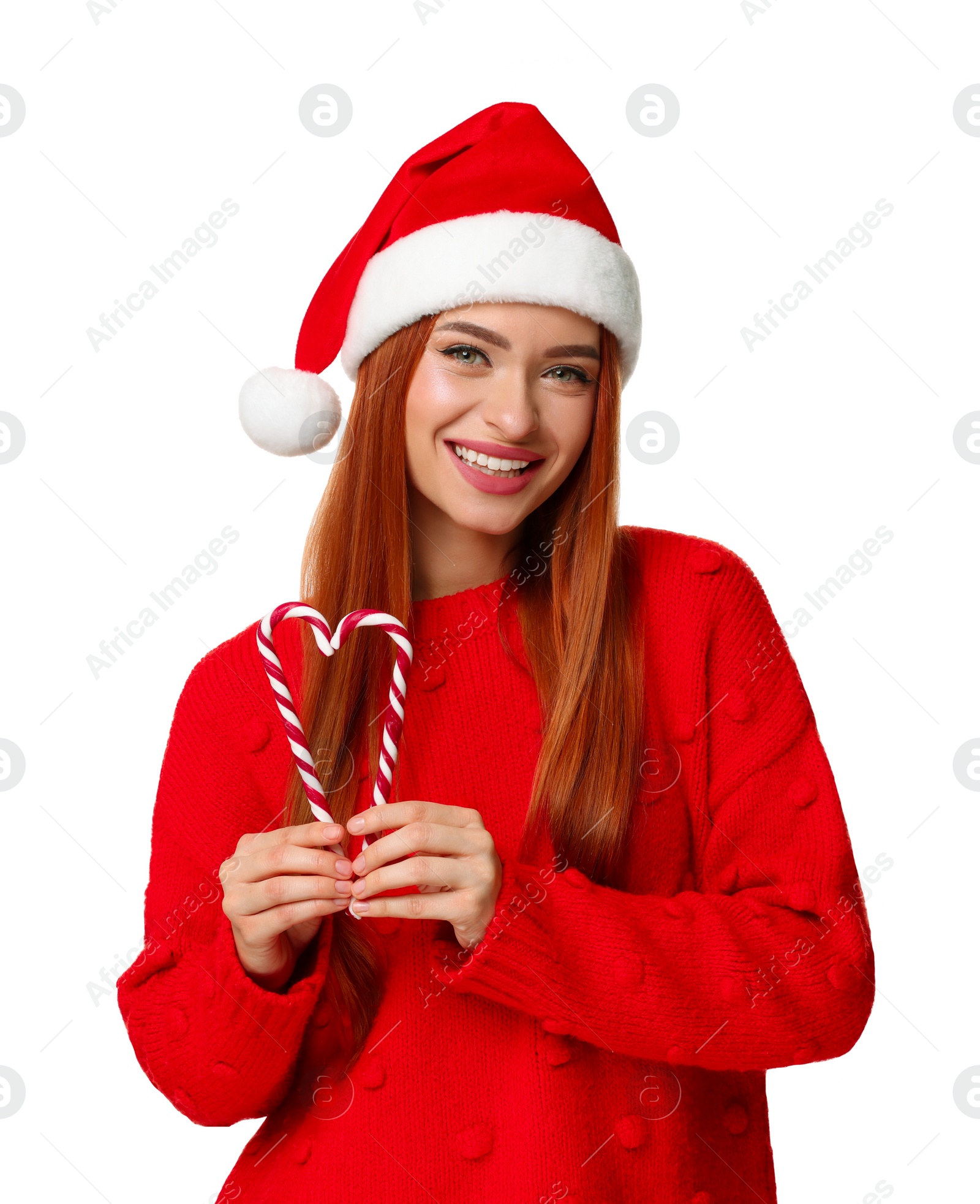 Photo of Young woman in red sweater and Santa hat with candy canes on white background. Christmas celebration