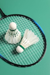 Feather badminton shuttlecocks and racket on green background