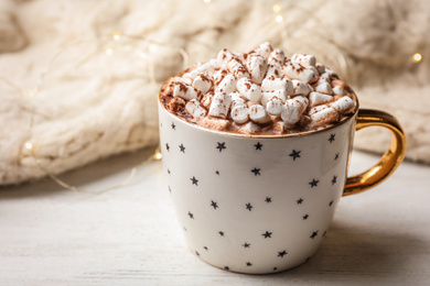 Photo of Cup of delicious hot cocoa with marshmallows on white wooden table