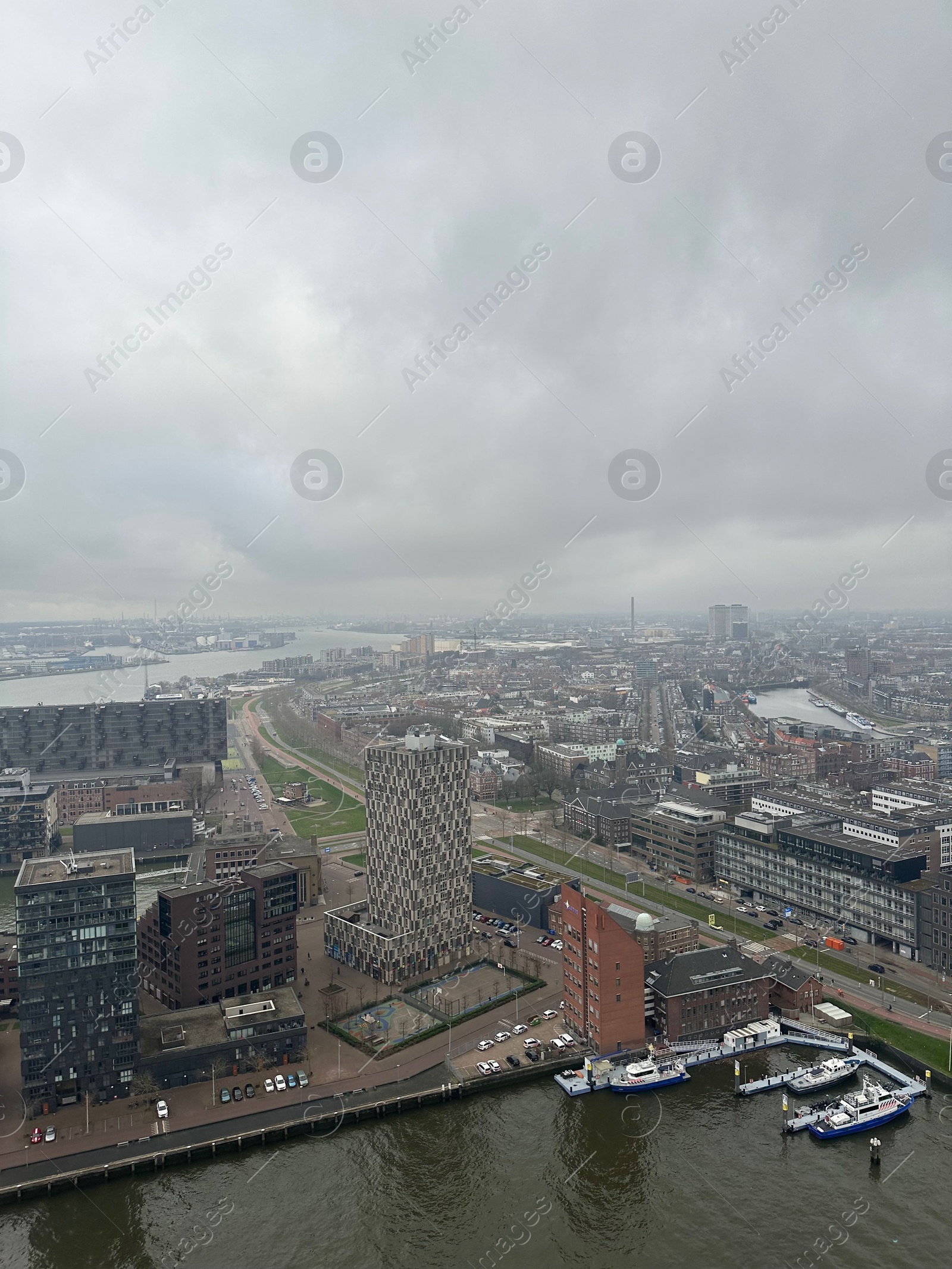 Photo of Picturesque view of city with modern buildings and harbor on cloudy day