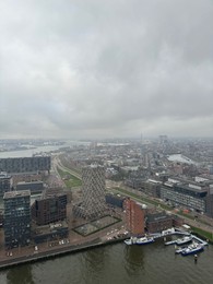 Photo of Picturesque view of city with modern buildings and harbor on cloudy day
