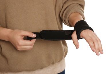 Woman wrapping hand in medical bandage on white background, closeup