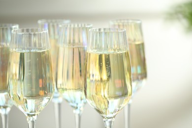 Photo of Glasses of champagne on blurred background, closeup view