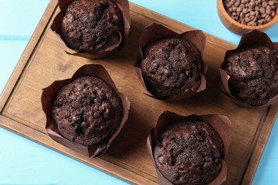 Photo of Tasty chocolate muffins on light blue wooden table, top view