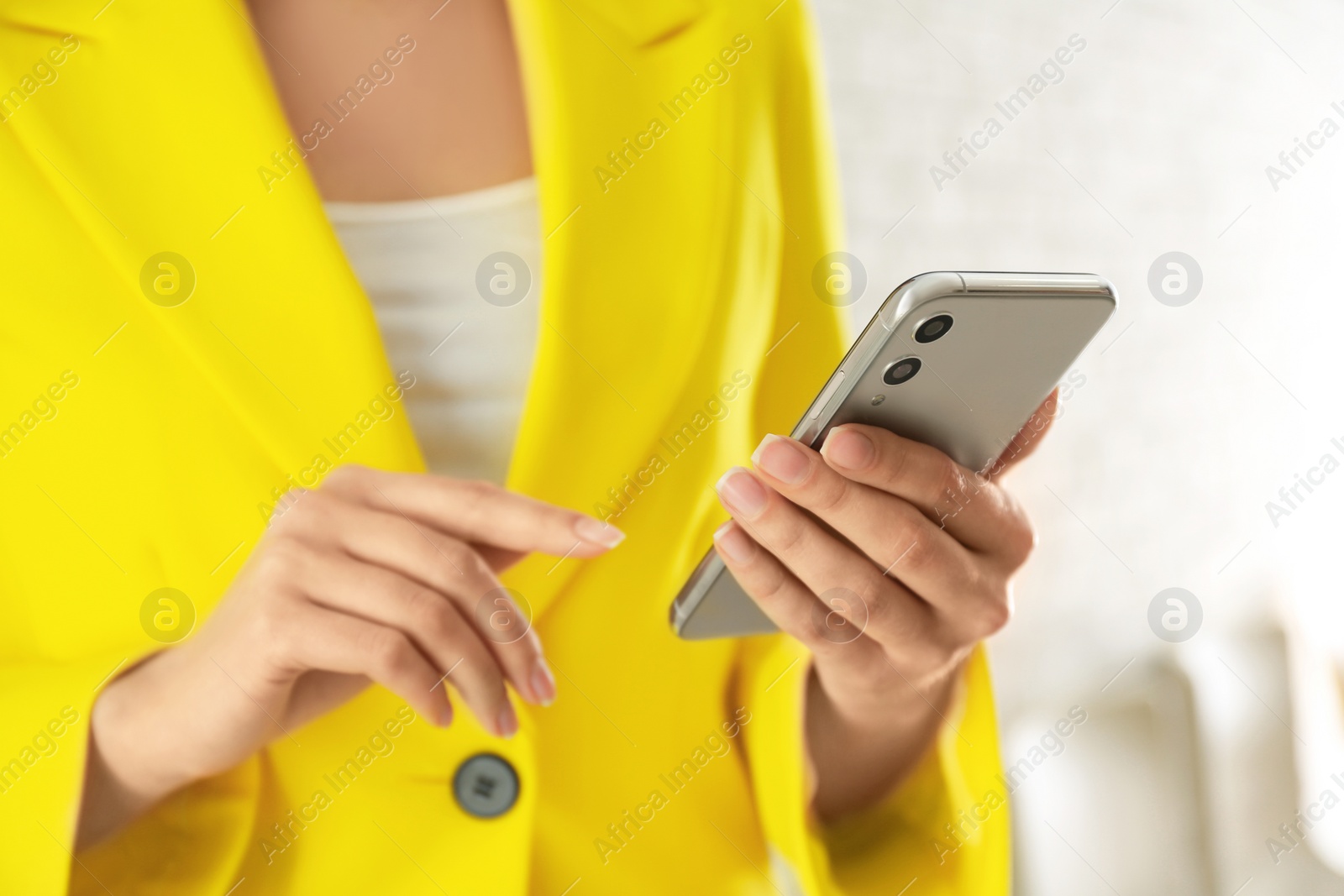 Photo of Young woman using modern smartphone indoors, closeup