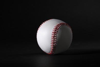 Photo of One leather baseball ball on black background