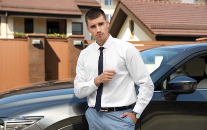 Attractive young man near luxury car outdoors