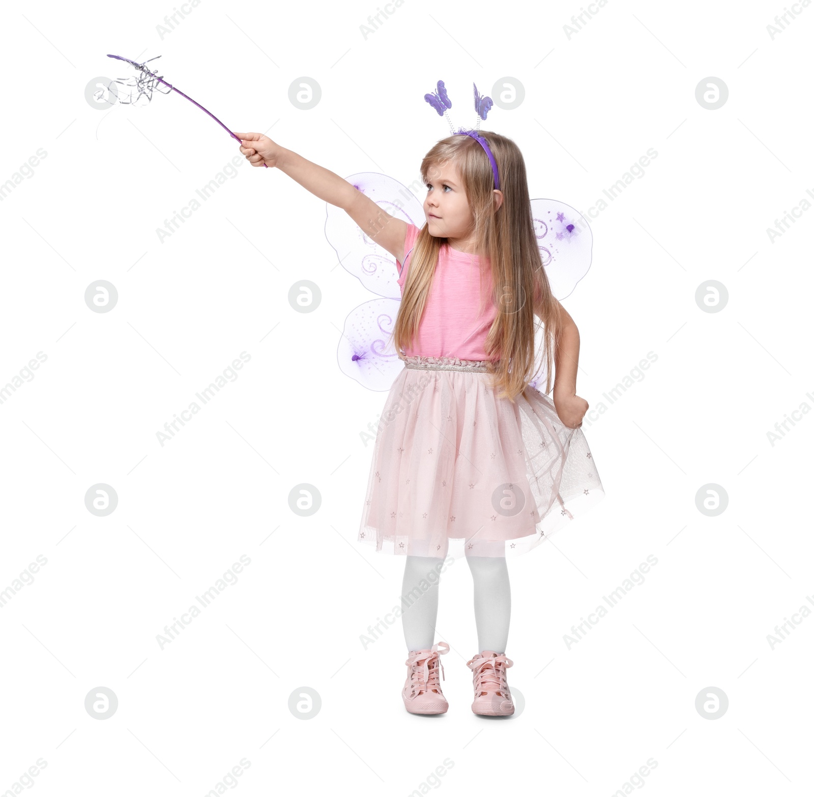 Photo of Cute little girl in fairy costume with violet wings and magic wand on white background