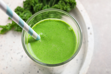 Photo of Tasty kale smoothie on light grey table, closeup