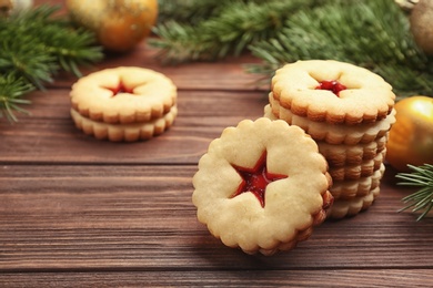 Photo of Traditional Christmas Linzer cookies with sweet jam on wooden table