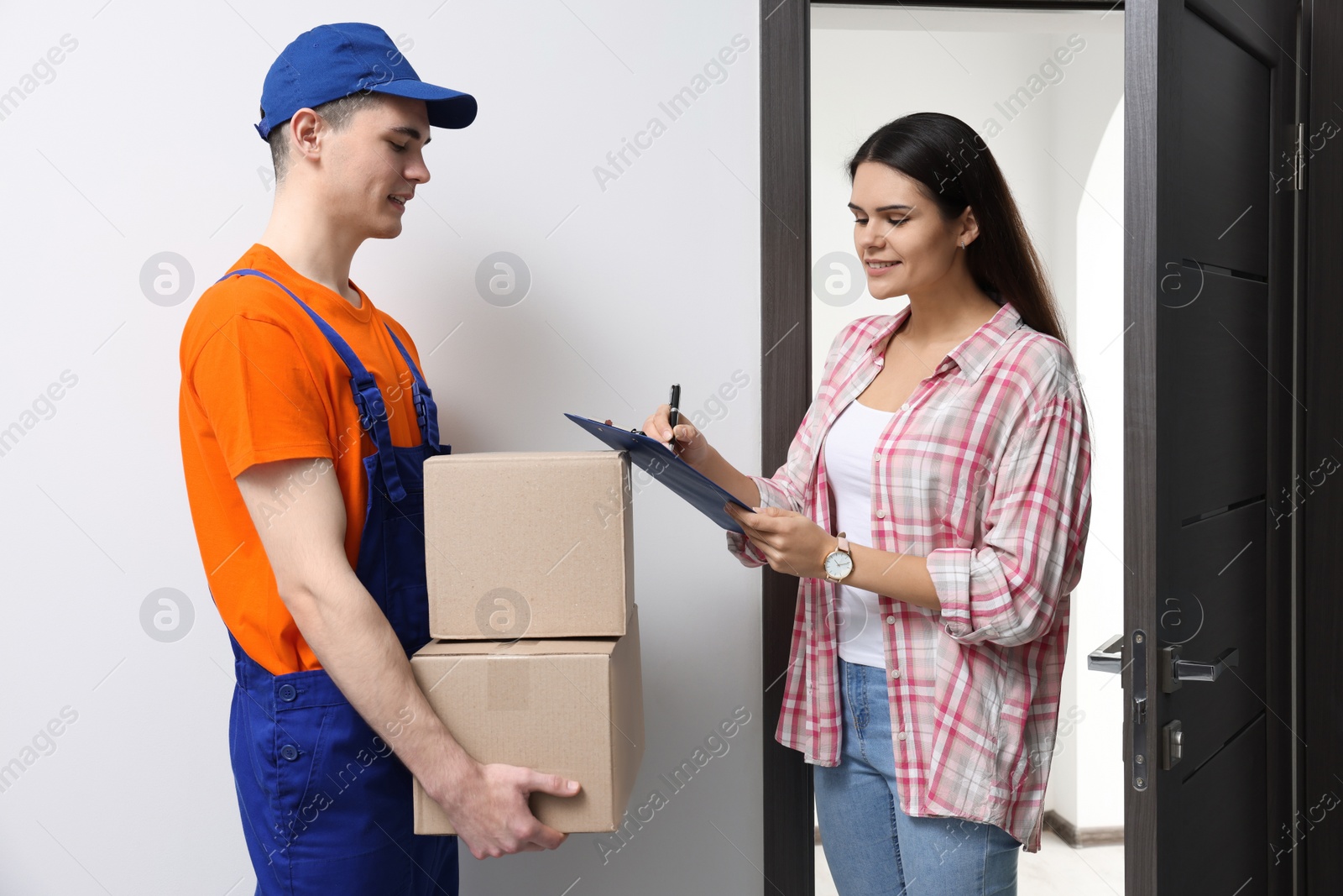 Photo of Woman receiving parcels from courier at home