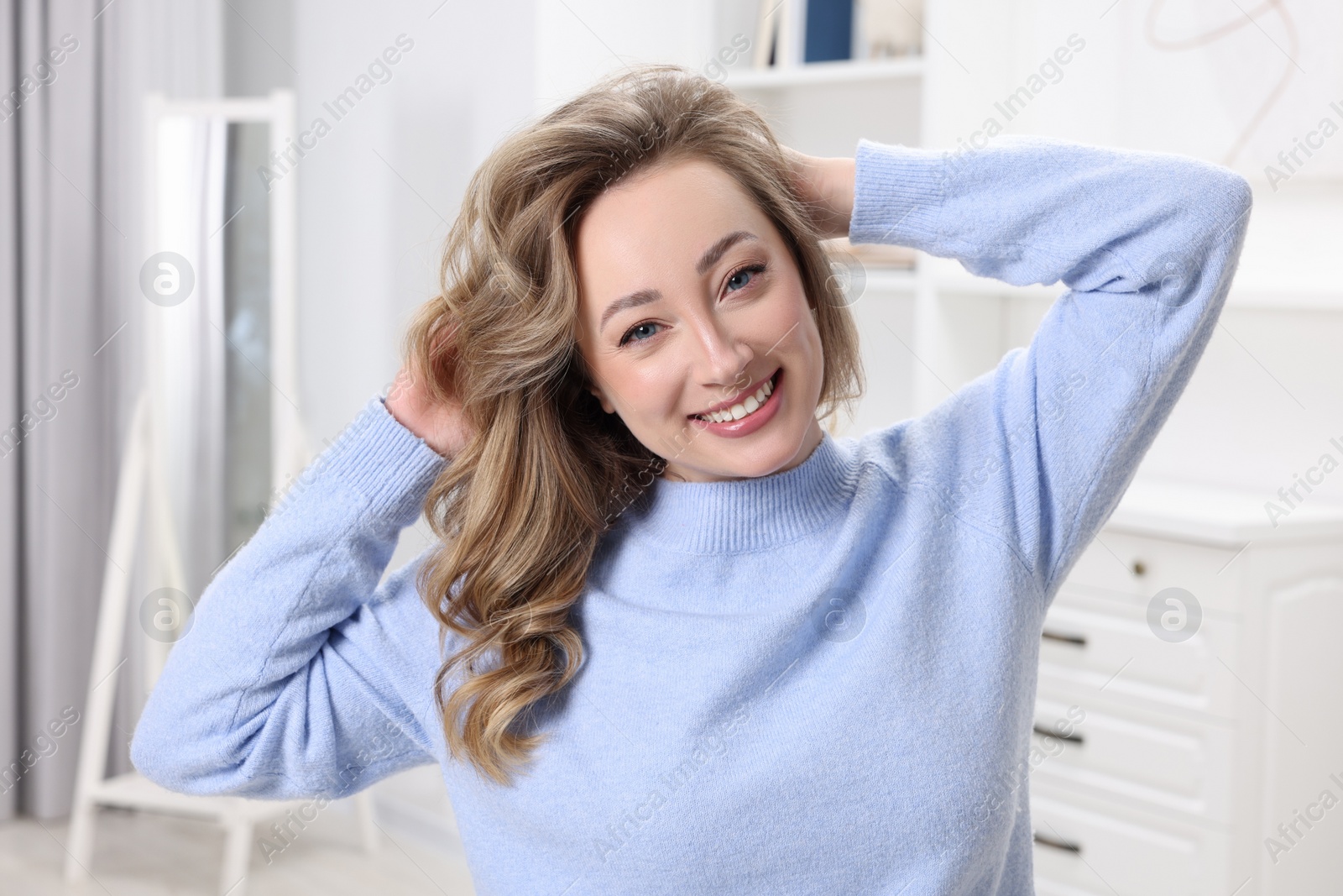 Photo of Portrait of smiling woman with curly hair at home