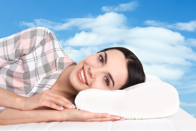 Young woman lying in bed. Blue sky on background