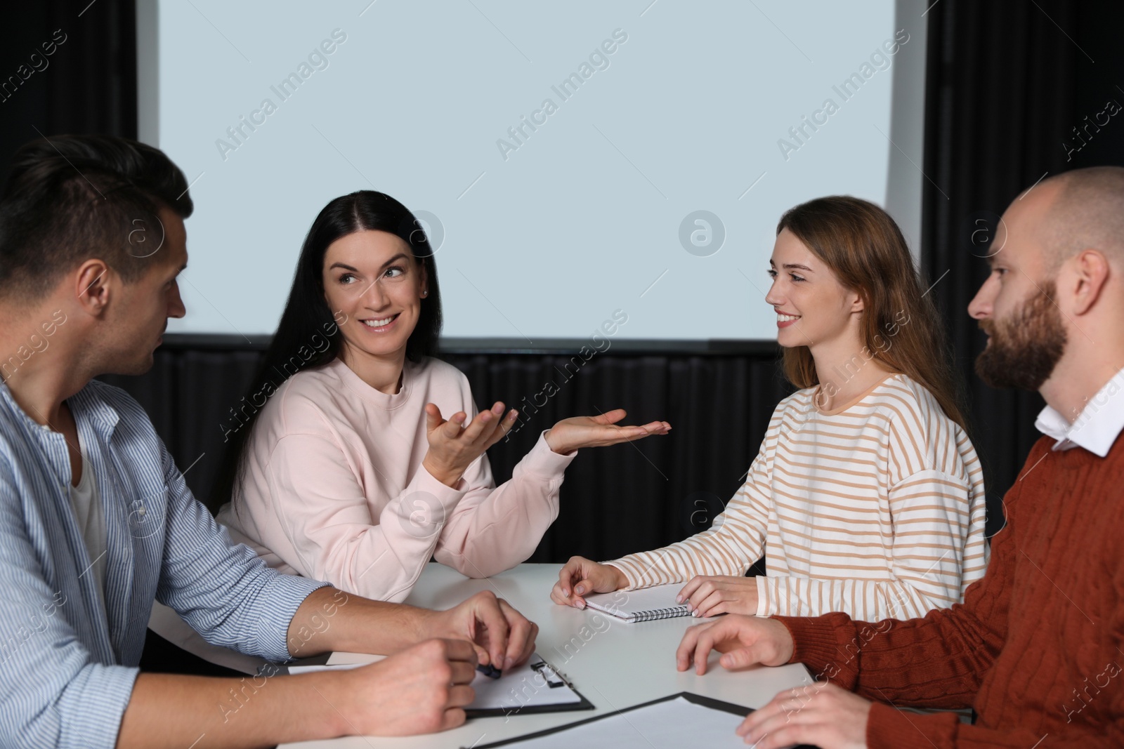 Photo of Business people having meeting in conference room with video projection screen