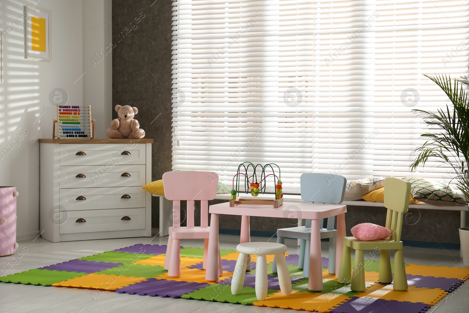 Photo of Stylish playroom interior with toys and modern furniture