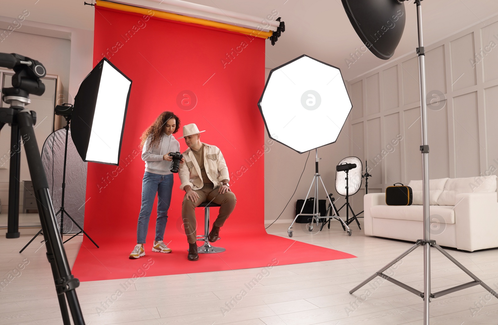 Photo of Handsome model with professional photographer in studio