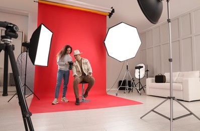 Photo of Handsome model with professional photographer in studio