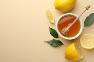 Photo of Ripe lemons, leaves, bowl of honey and dipper on beige background, flat lay. Space for text