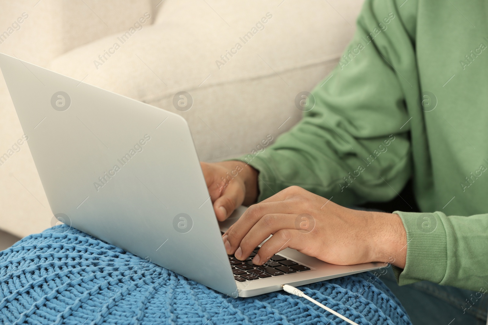 Photo of African American man typing on laptop indoors, closeup