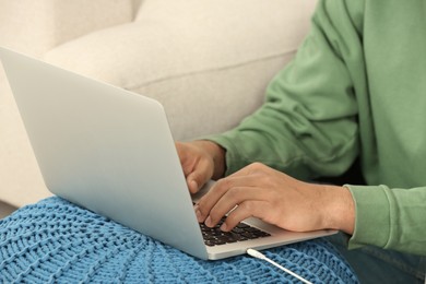 Photo of African American man typing on laptop indoors, closeup