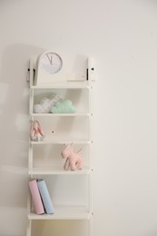Photo of Shelving unit with toys near light wall in child room