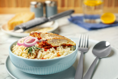 Photo of Delicious chicken risotto served in bowl on table