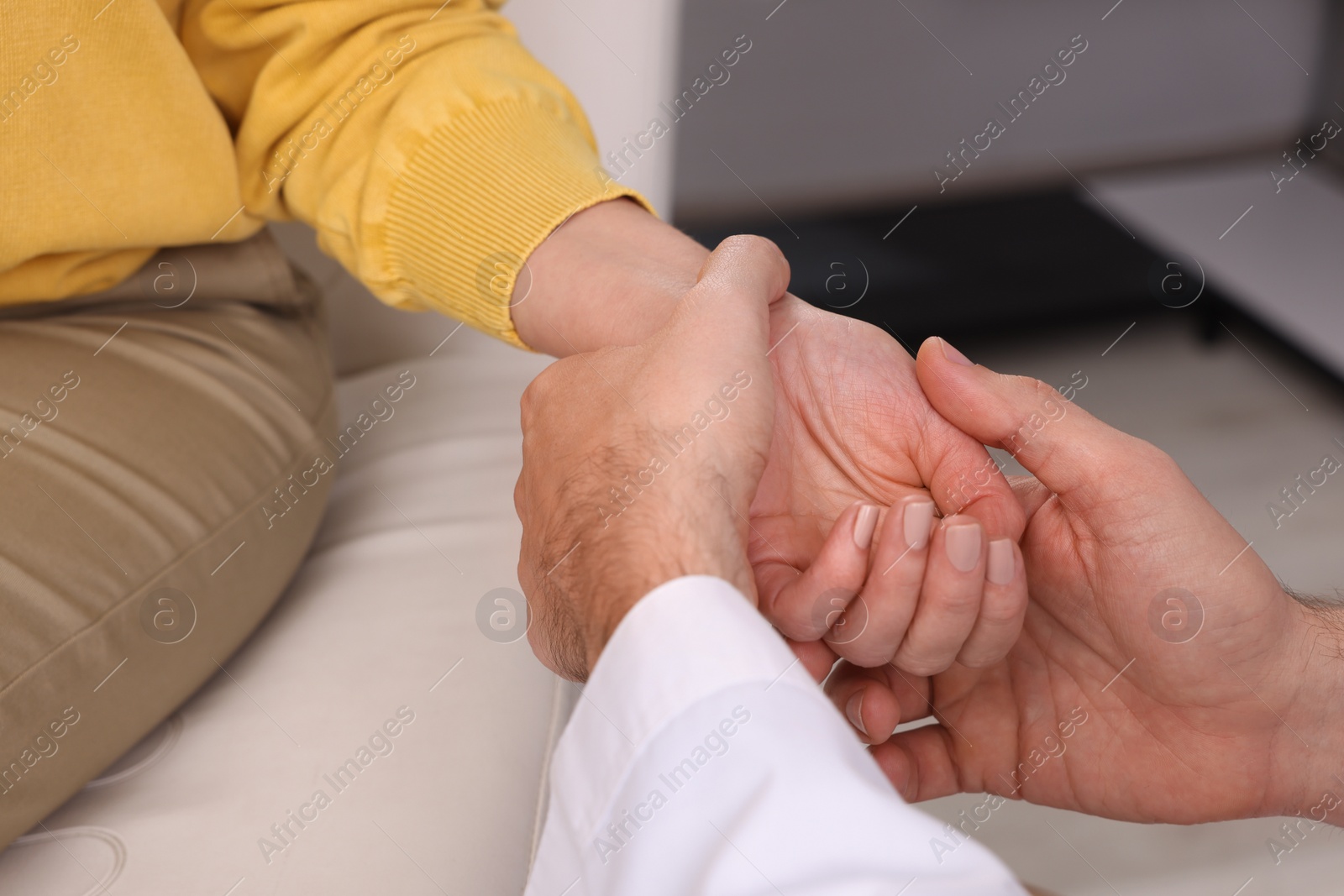 Photo of Doctor checking patient's pulse in clinic, closeup