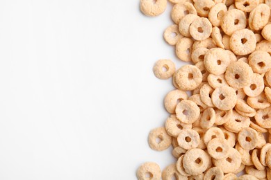 Photo of Tasty cereal rings on white background, flat lay. Space for text