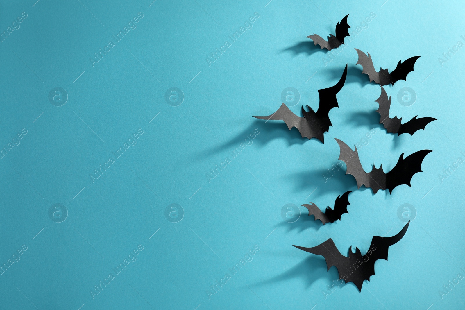 Photo of Flat lay composition paper bats on light blue background, space for text. Halloween decor