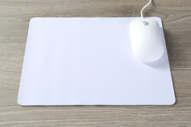 Wired mouse and mousepad on wooden table