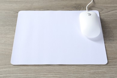 Photo of Wired mouse and mousepad on wooden table