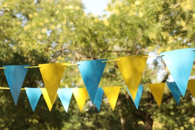 Colorful bunting flags in park. Party decor