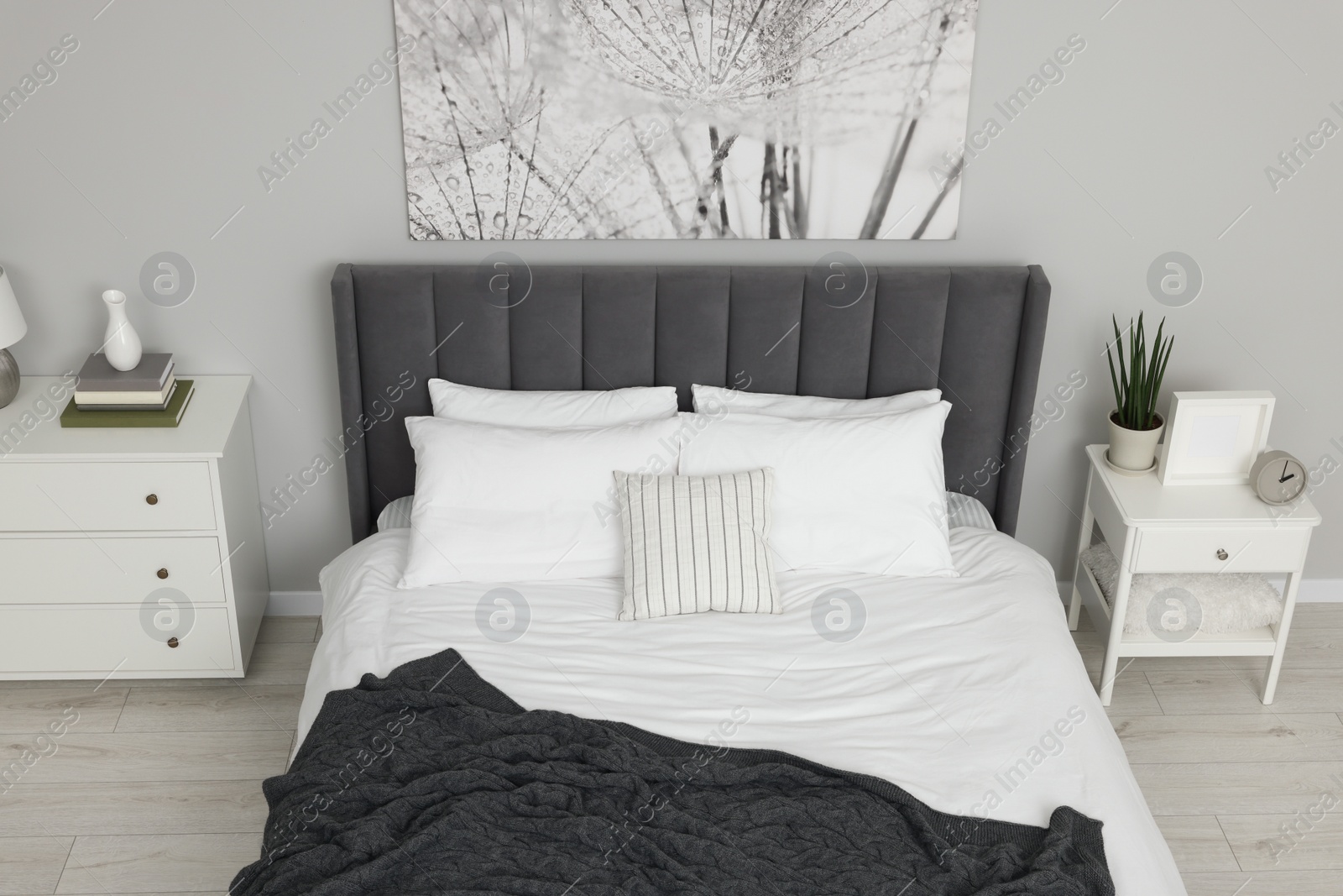 Photo of Stylish bedroom interior with large comfortable bed and chest of drawers, above view
