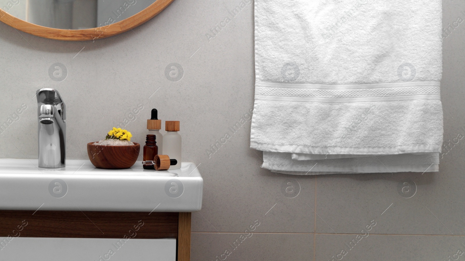 Photo of Hanging towel, sink and toiletries in bathroom. Interior design