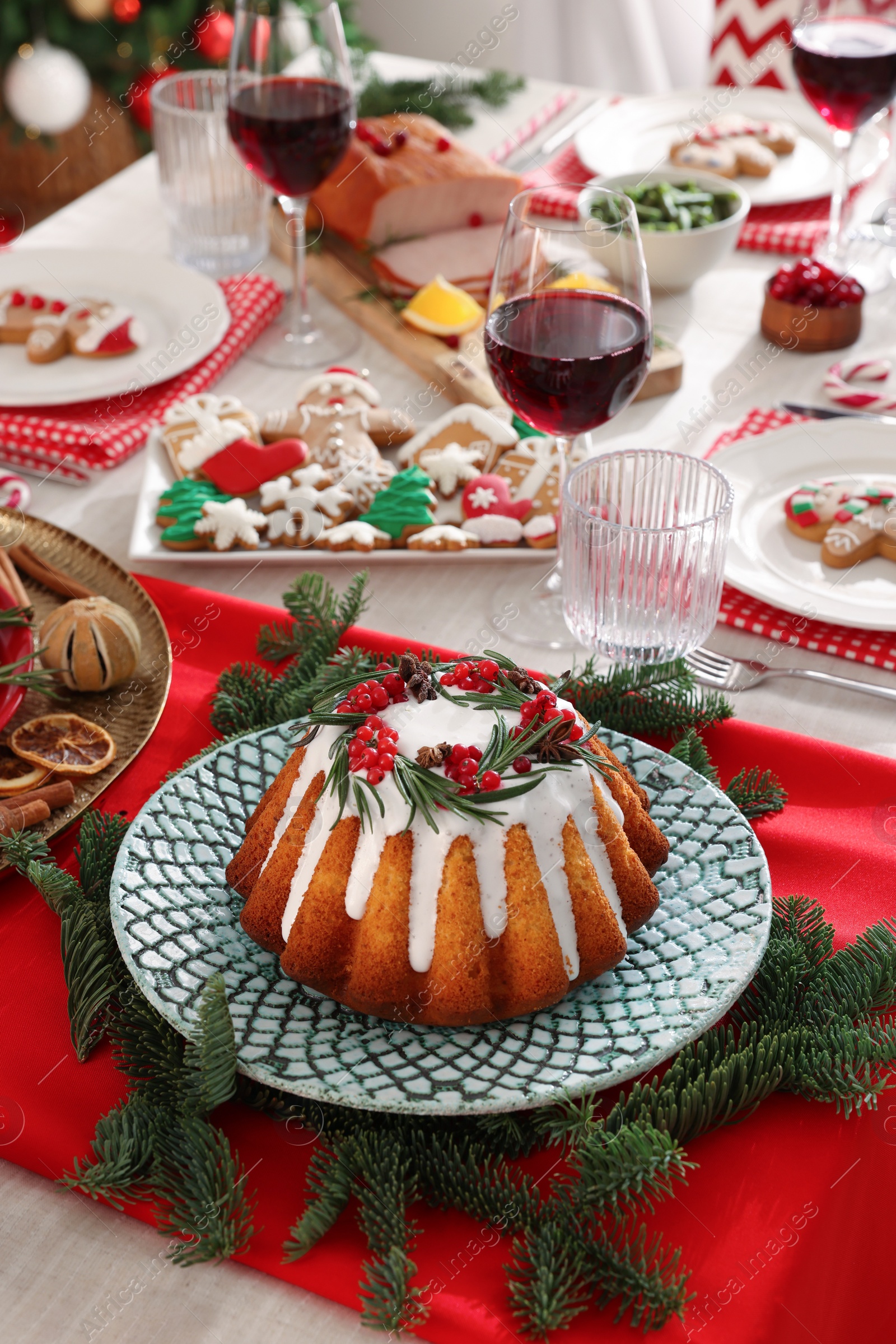 Photo of Festive dinner with delicious cake served on table indoors. Christmas Eve celebration