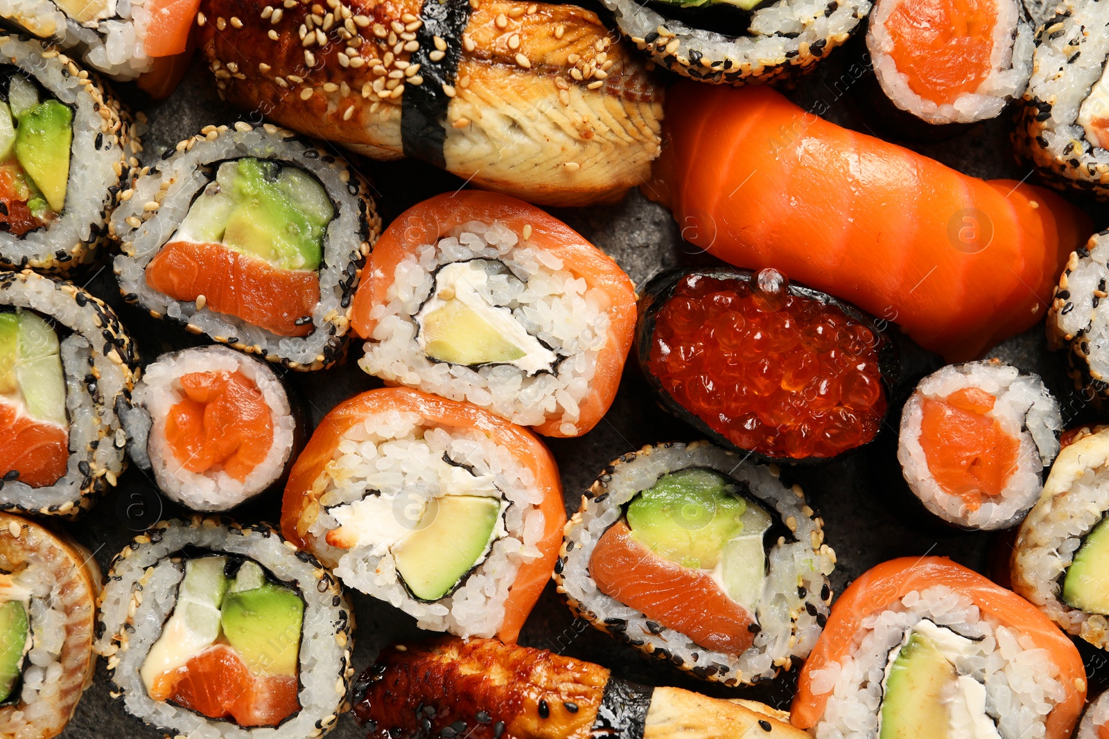 Photo of Different tasty sushi rolls as background, top view