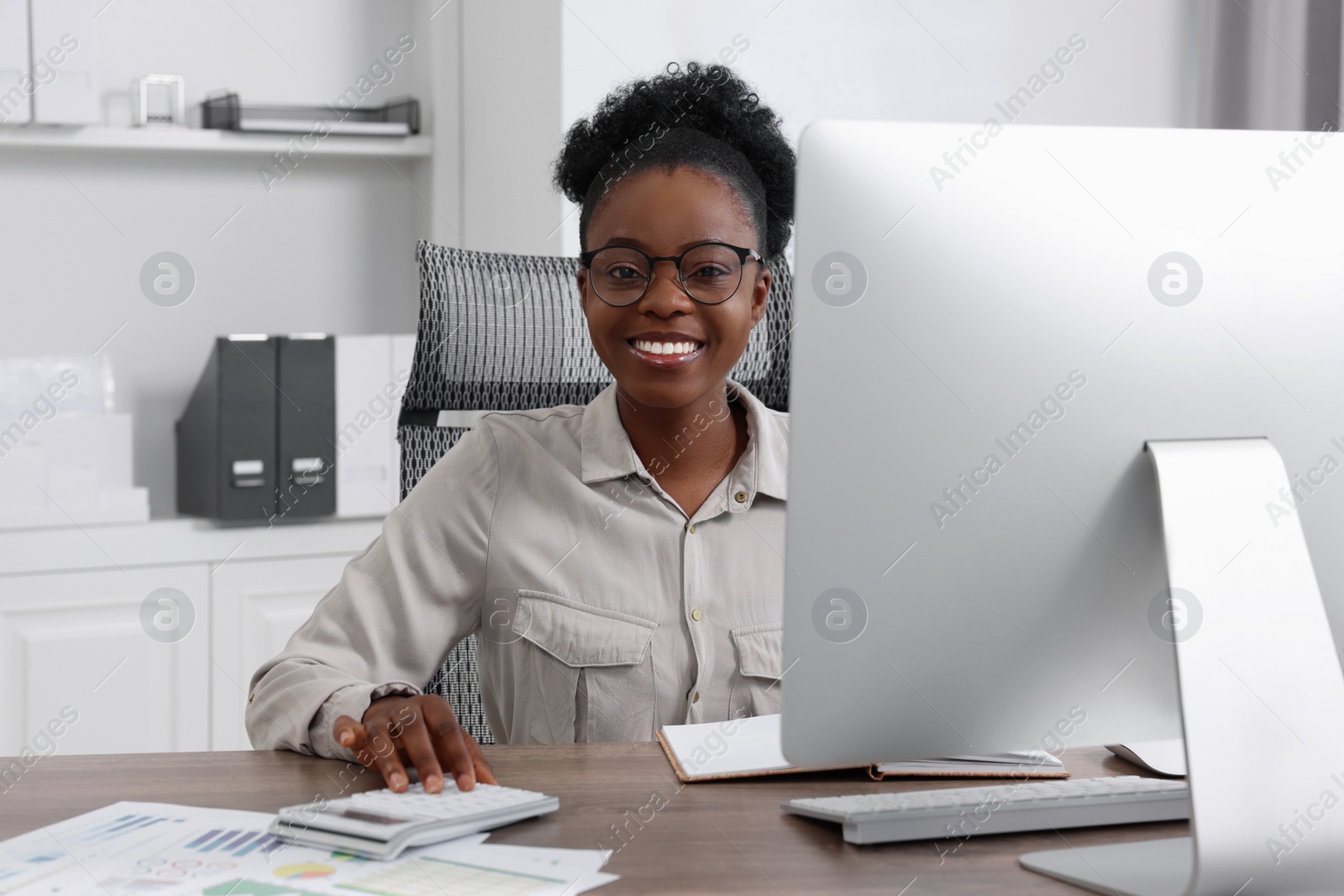 Photo of Professional accountant working on computer at wooden desk in office