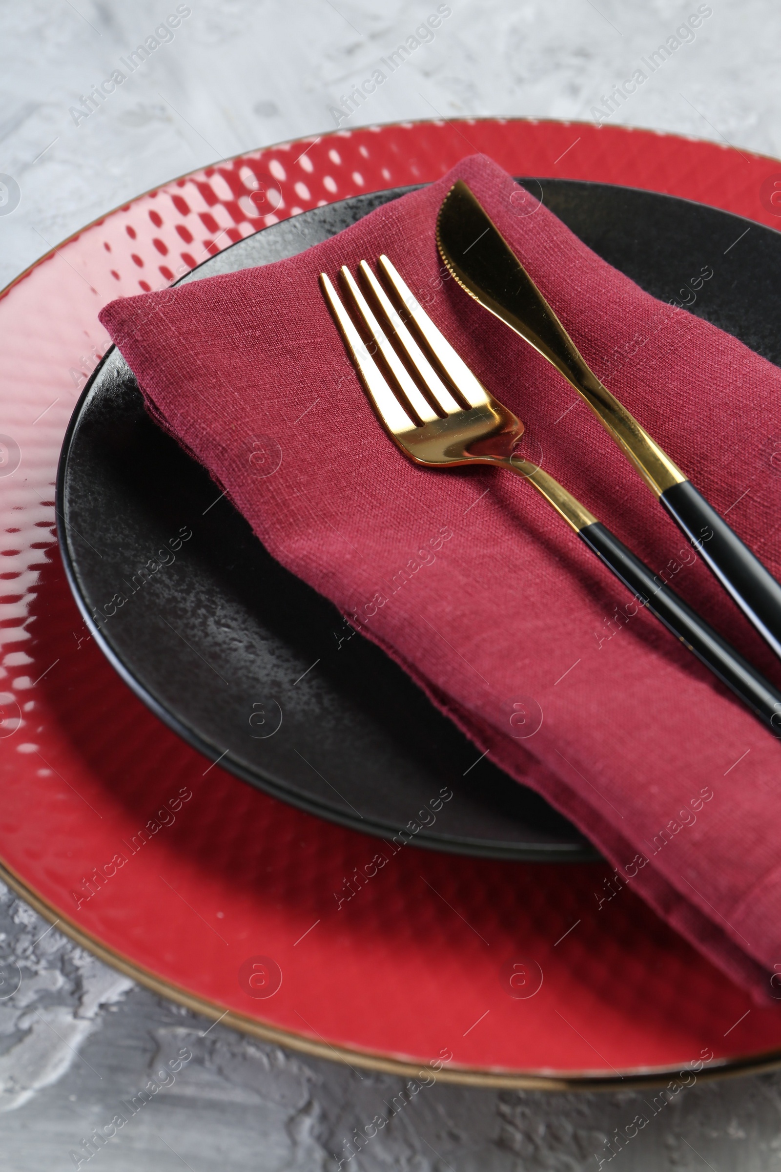 Photo of Clean plates, cutlery and napkin on table, closeup