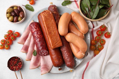 Photo of Different types of tasty sausages and ingredients on white table, flat lay