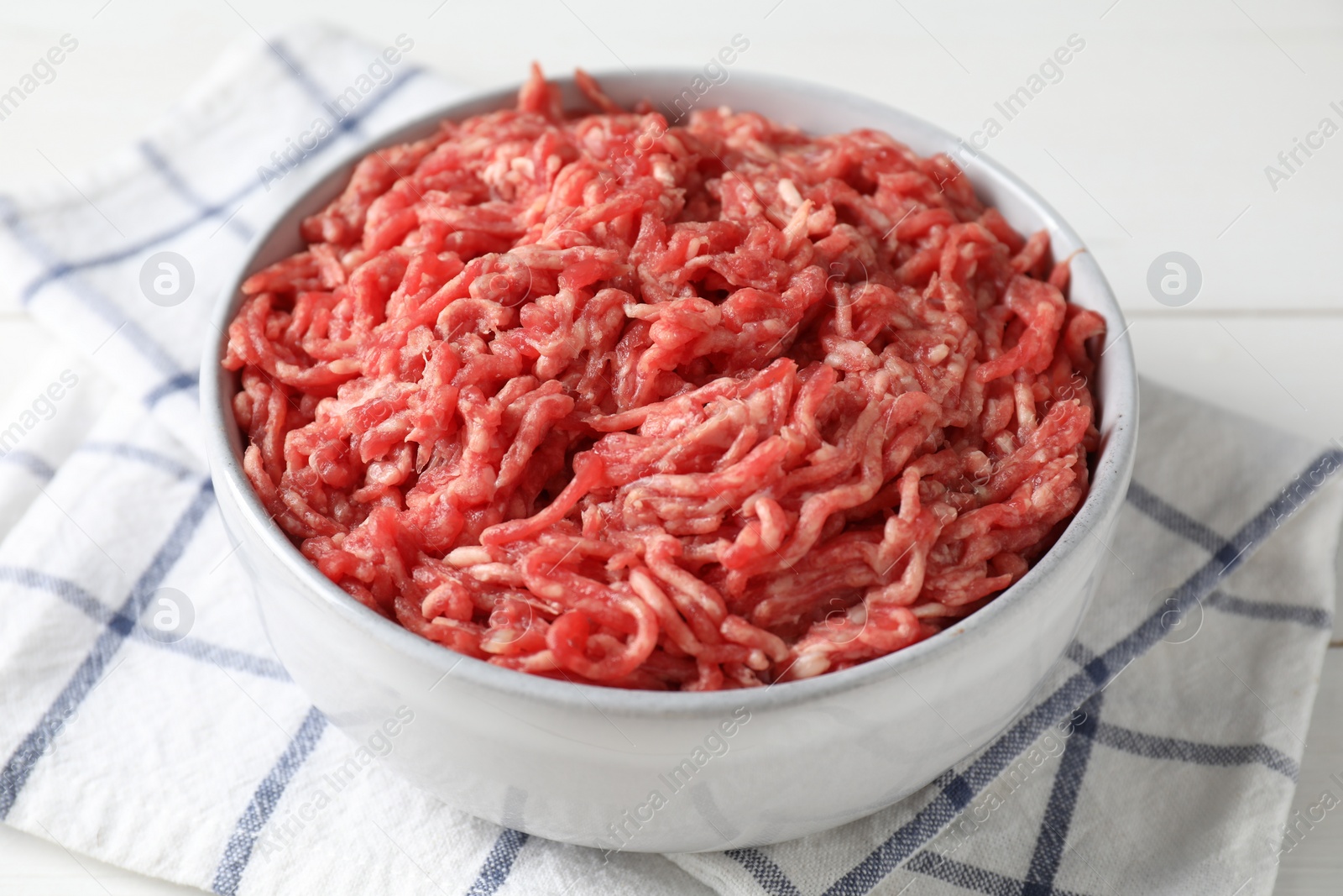 Photo of Raw ground meat in bowl on table, closeup