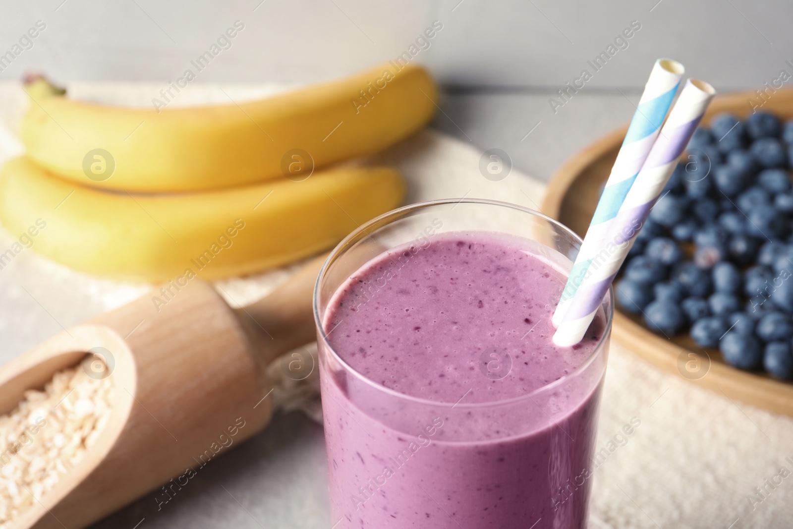 Photo of Glass with blueberry smoothie on table, closeup